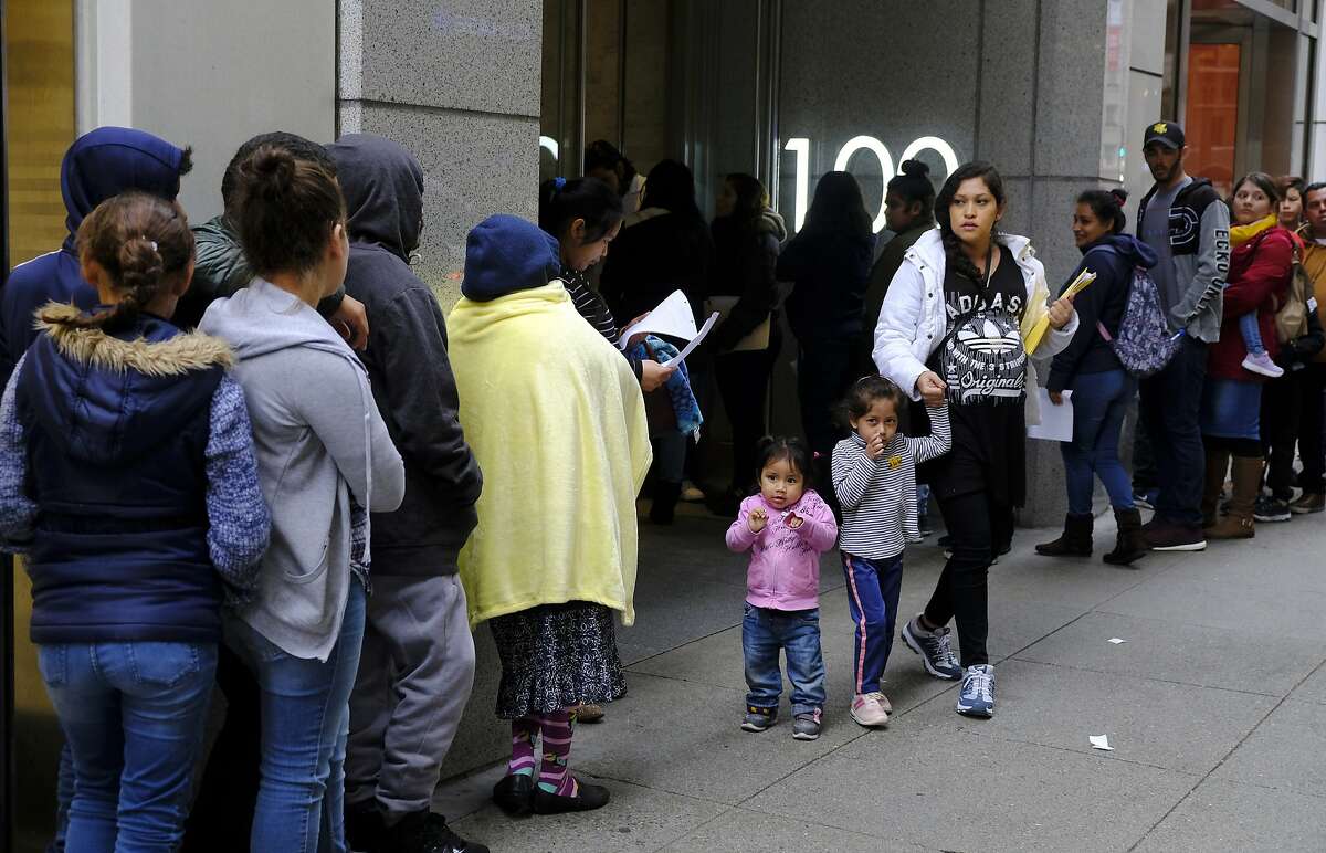File - In this Jan. 31, 2019, file photo, hundreds of people overflow onto the sidewalk in a line snaking around the block outside a U.S. immigration office with numerous courtrooms in San Francisco. Federal judges are being asked to block a new Trump administration policy scheduled to take effect next week that would deny legal permanent residency to many immigrants over the use of public benefits. Almost a dozen lawsuits have been filed from New York to California to prevent the "public charge" rule from taking effect on Oct. 15. Judges have indicated a willingness to issue rulings before the scheduled start date. (AP Photo/Eric Risberg, File)