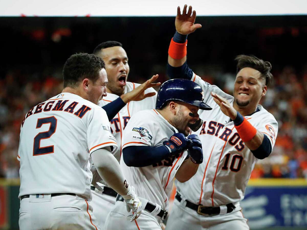 Astros second baseman Jose Altuve, center, is celebrated at home plate after hitting a game-winning, two-run, walk-off home run in Game 6 to win the American League Championship Series against the New York Yankees.