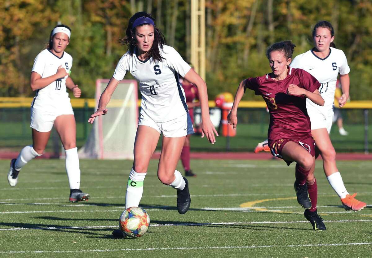 Mia Gonzalez (center) of Staples moves the ball up the field against St. Joseph in Trumbull on October 21, 2019.