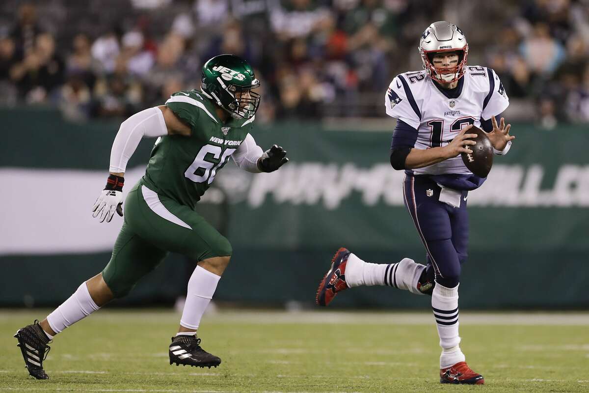 New York Jets' Jordan Willis (60) chases New England Patriots' Tom Brady (12) during the second half of an NFL football game Monday, Oct. 21, 2019, in East Rutherford, N.J. (AP Photo/Adam Hunger)