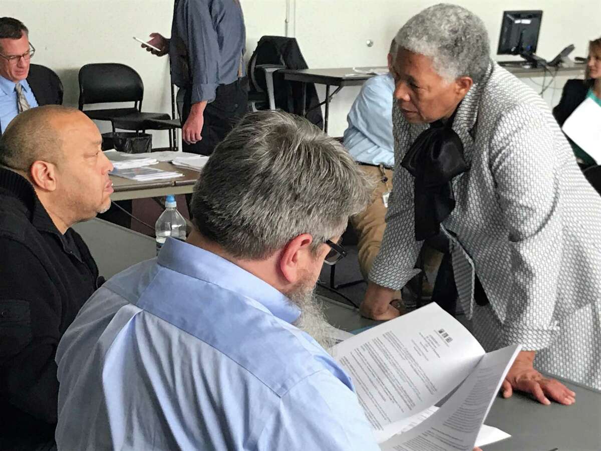 Acting Superintendent of Schools Iline Tracey speaks with New Haven Board of Education members Darnell Goldson and Matt Wilcox before an Oct. 21, 2019 finance committee meeting.