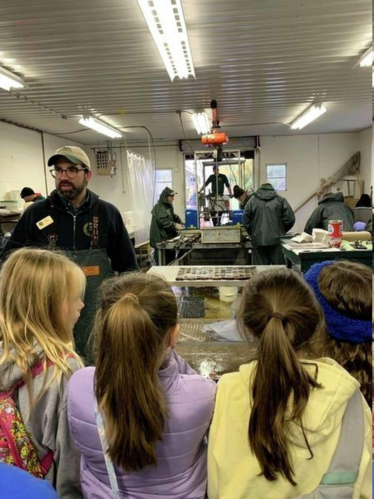 Onekama Consolidated School fifth grade students are explained the egg harvest process by a Department of Natural Resources employee at the Platte River Hatchery. (Courtesy photo)