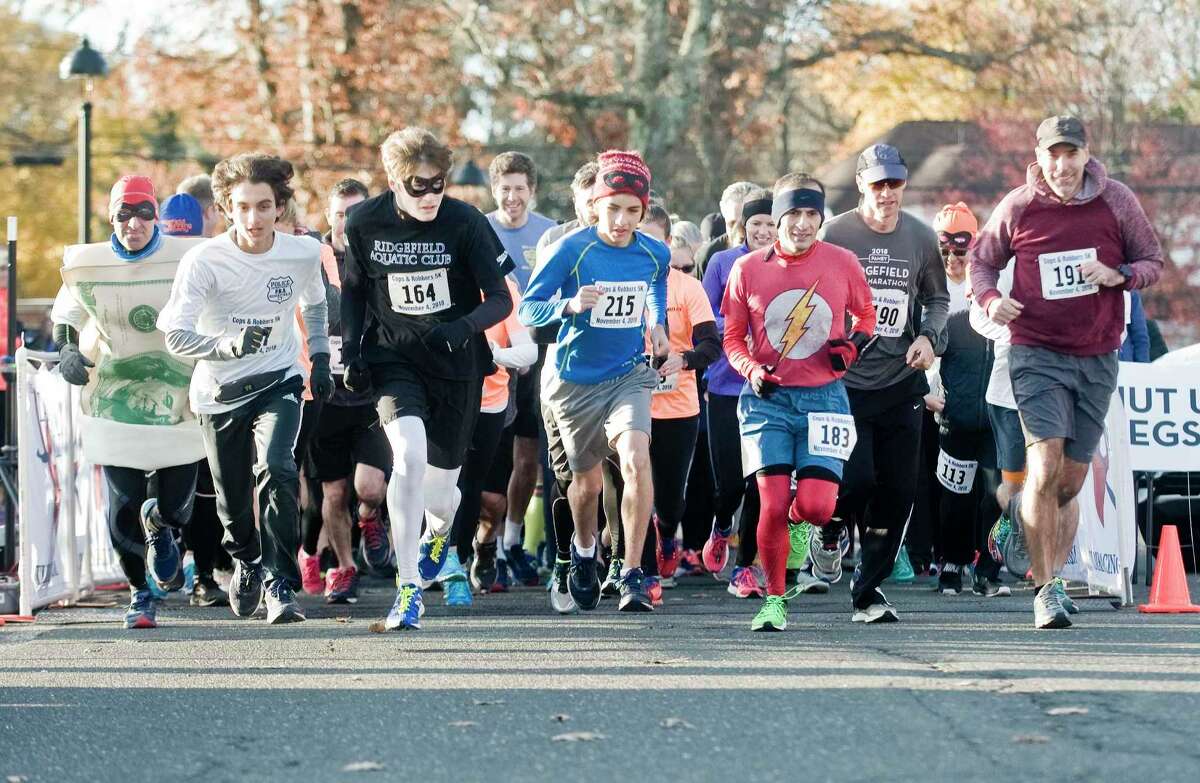 Runners take off from the starting line of the annual Cops and Robbers 5K at The Ridgefield Playhouse in November 2018.