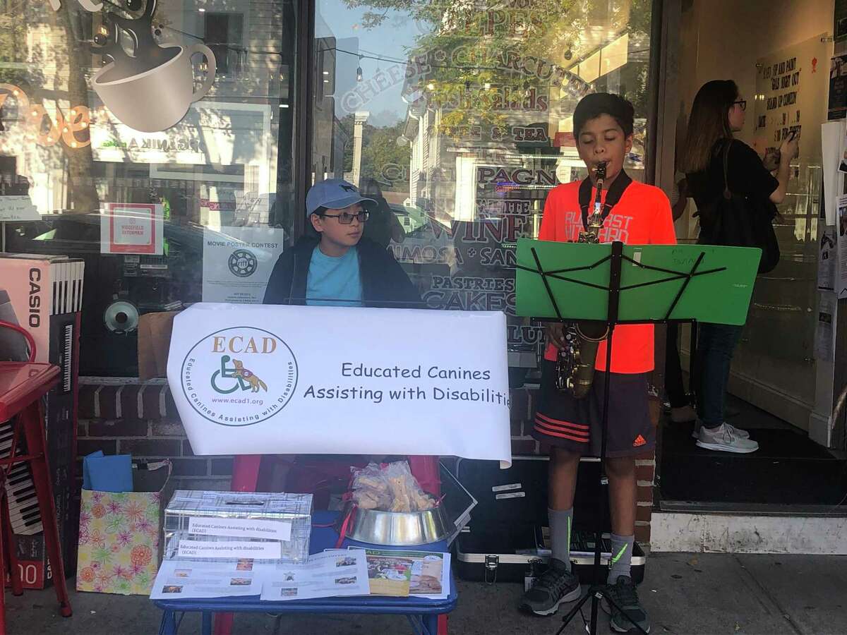 Tyler Hilford and Aakarsh Patel, left to right, perform as the “Musical Rescuers” in front of Kafo on Main Street.