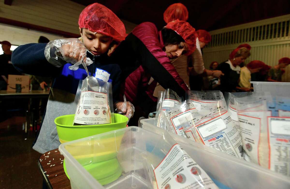 Hundreds of volunteers including Wilton resident Ishan Chuch, 8, and his mom Gauri Chugh package meals for Wilton’s Wi-ACT Interfaith Committee the 6th annual Rise Against Hunger meal packaging event Saturday, October 19, 2019, at Wilton Presbyterian Church in Wilton, Conn. Four shifts of nearly 750 volunteers will load a shipping container destined for Somalia with the completed meals.