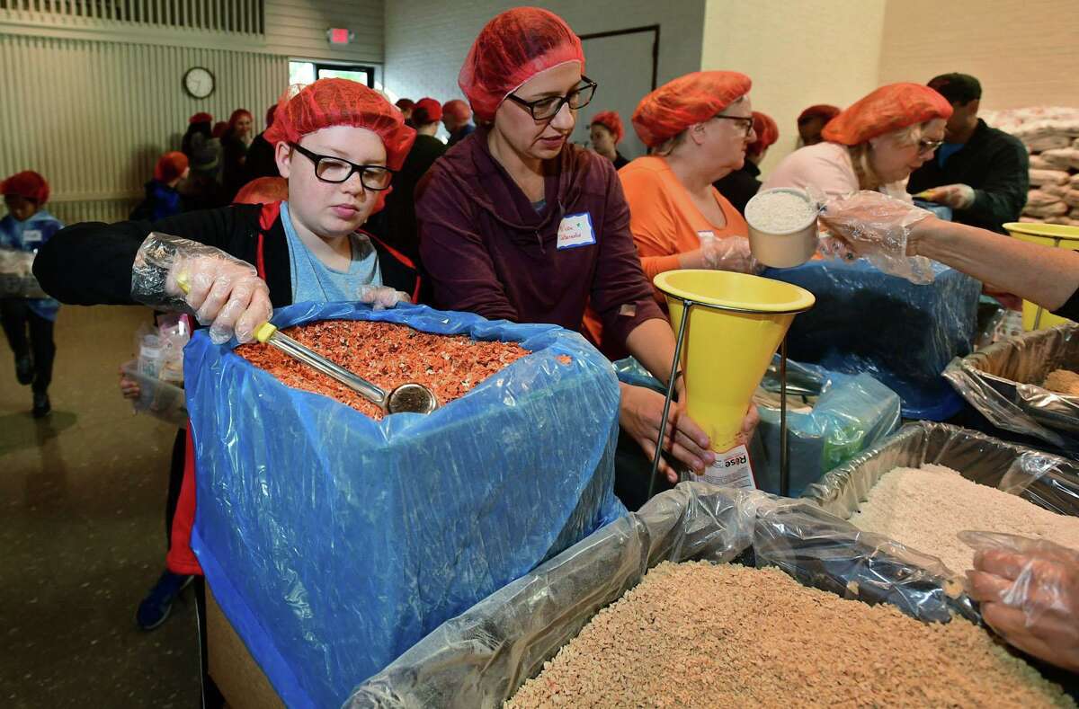 William DeBernardis, 11, and his mom, Melissa DeBernardis, work one of the volunteer shifts packaging meals. Each year the meals are sent to a different part of the world, wherever the need is greatest. The children receiving the meals eat them at school, where not only their bodies are nourished but their minds as well.