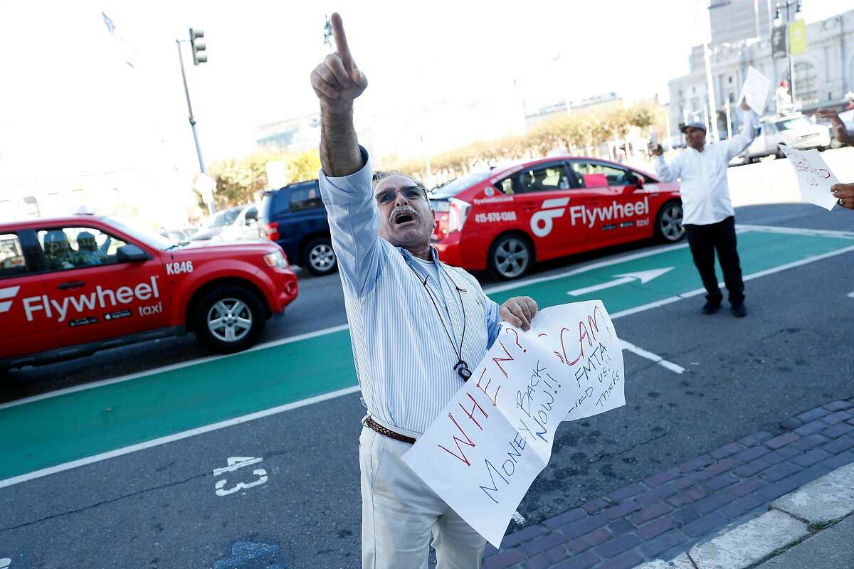 Taxi driver Alan Khani points towards City Hall as he joins protest in San Francisco, Calif., on Tuesday, October 22, 2019.