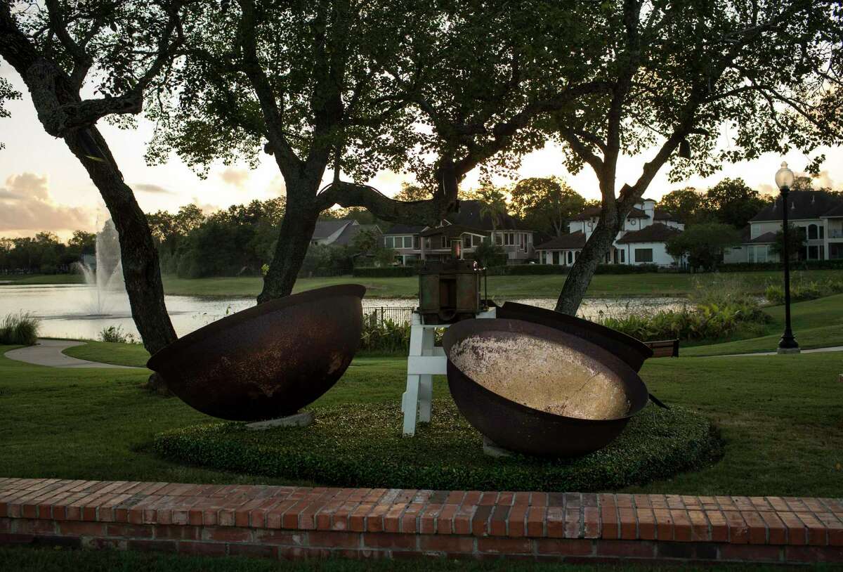 A sugar cane mill and three large bowls are photographed at a history park in Sienna Plantation on Thursday, Oct. 10, 2019, in Missouri City. According to a sign at the park, the mill, a "Kentucky #2" 725 pound mill, was produced between 1888-1905, and it was powered by two mules turning in a circle. This type of mill would have been used to crush sugar cane grown in the region in the mid 1800s.