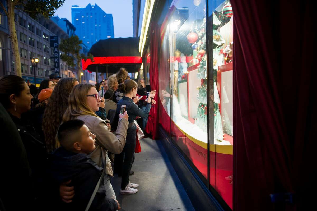 Visitors watch the adoptable puppies and kittens at the Macy's windows in San Francisco in 2018.