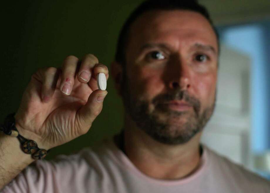 Greg Casillas shows the medication Triumeq, which he takes daily for HIV. For various reasons, he was reluctant to go on medication for HIV for 17 years. He started taking the pill in 2017. Photo: Kin Man Hui / ©2019 San Antonio Express-News