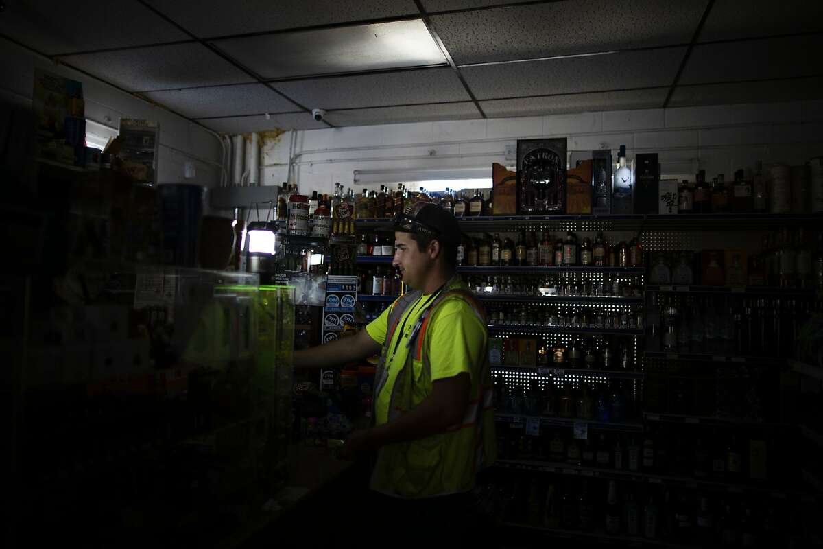 Joshua Motil, buying Beef Jerky and flavored at the Calistoga Liquor, that had its electricity cut by PG&E in attempts to prevent fires during extreme fire conditions,Calistoga, September 25th, 2019. Motil was taking a delivery to a construction site where the owners where rebuilding their home that was destroyed from a fire 2 years ago. His own home was nearly burnt in the Tubbs fire, and he helped save his stayed at his parents home in Coffee Park hosing it down during the Tubbs fired that destroyed most of the neighborhood. PG&E shut off electricity to parts of Calistoga in attempts to prevent fire started by their lines during extreme fire conditions. The first report of the Tubbs Fire came from Hwy 128 and Tubbs lane -where Calistoga Liquor store is located.