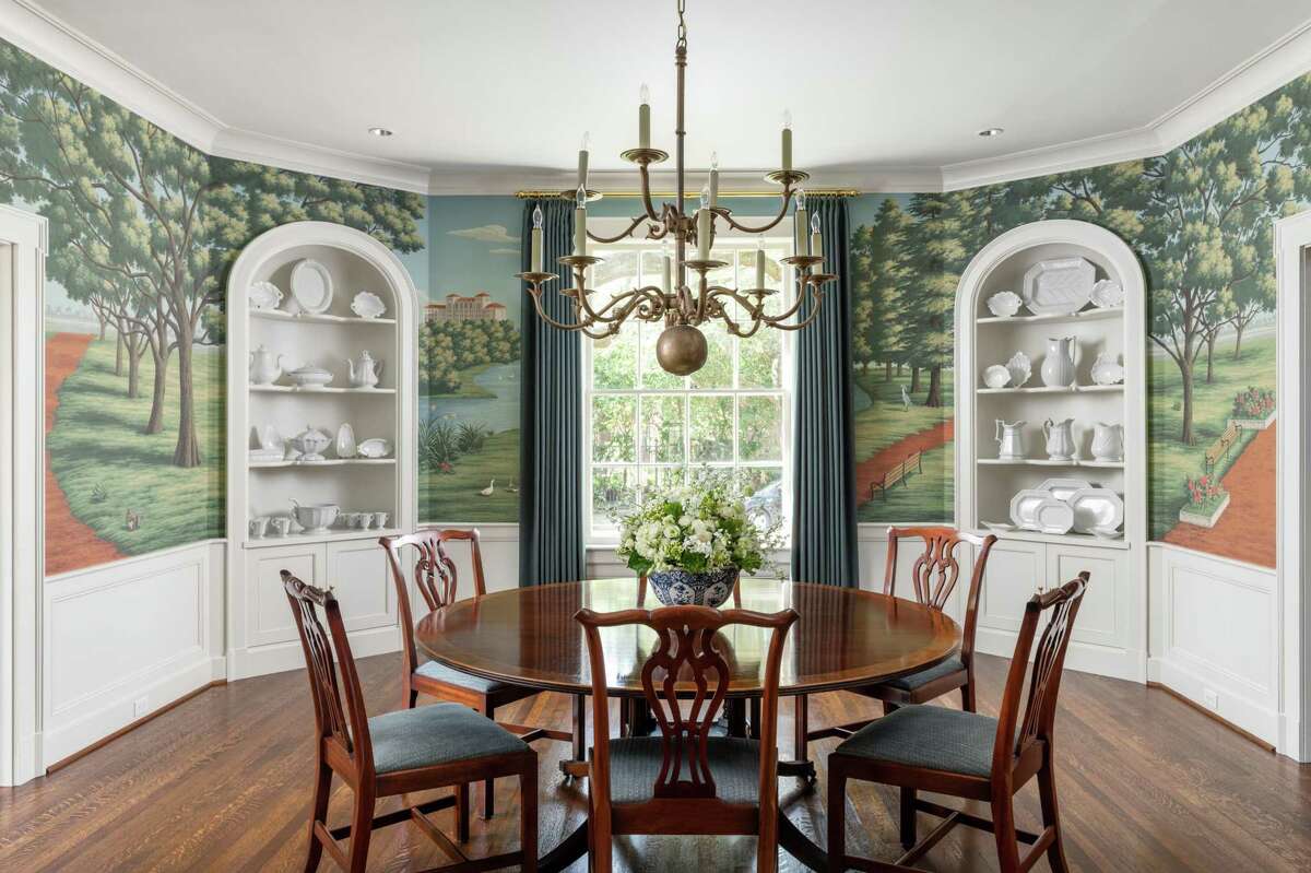 The dining room got the most impressive transformation, with custom, hand-painted de Gournay wallpaper with a depiction of Hermann Park as it looked in 1929. Cast plaster cabinets were added to each corner and white ironstone dishes are displayed there.