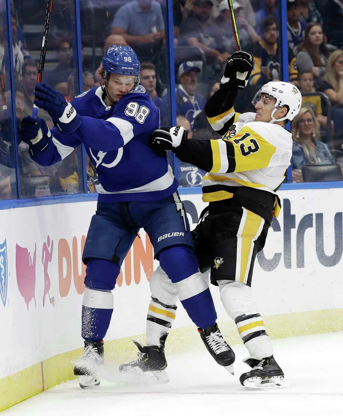 Pittsburgh Penguins left wing Brandon Tanev (13) checks Tampa Bay Lightning defenseman Mikhail Sergachev (98) into the boards during the first period of an NHL hockey game Wednesday, Oct. 23, 2019, in Tampa, Fla. (AP Photo/Chris O'Meara)