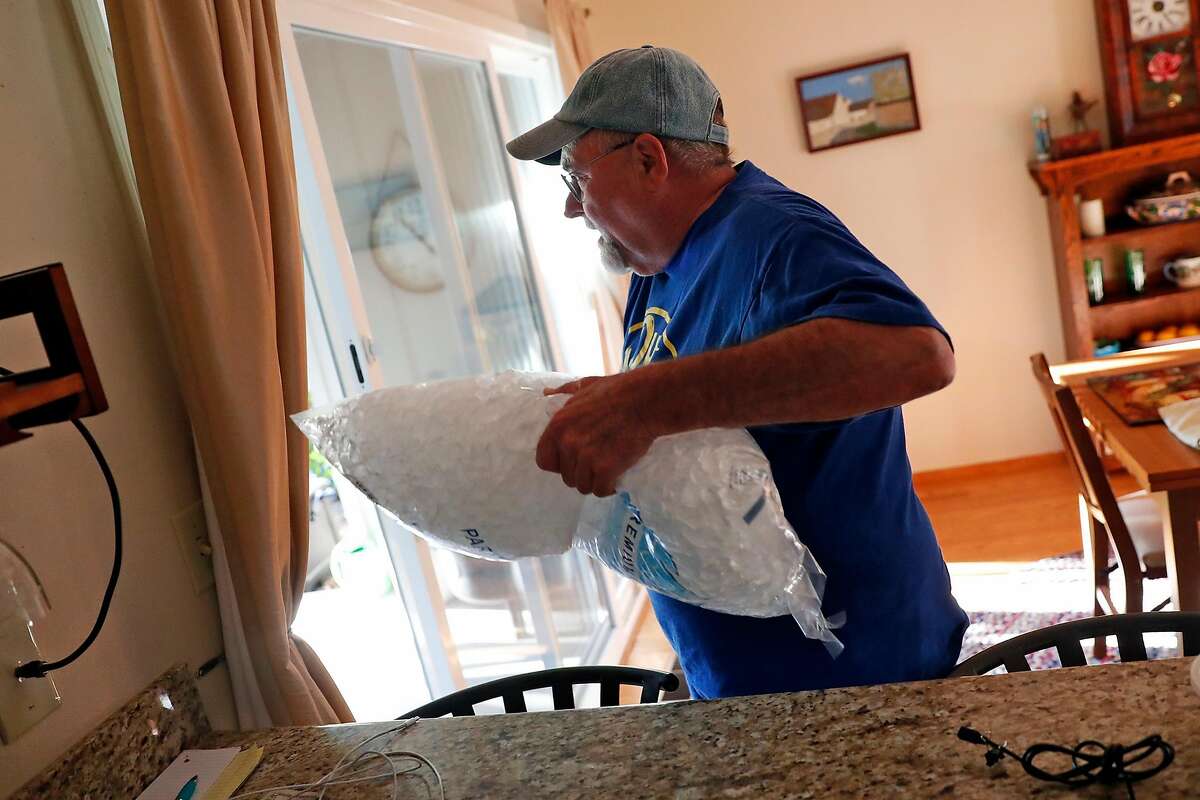 Ken Garcia arrives home with a bag of ice during PG&E power shut-off at their home in Santa Rosa, Calif., on Wednesday, October 23, 2019.