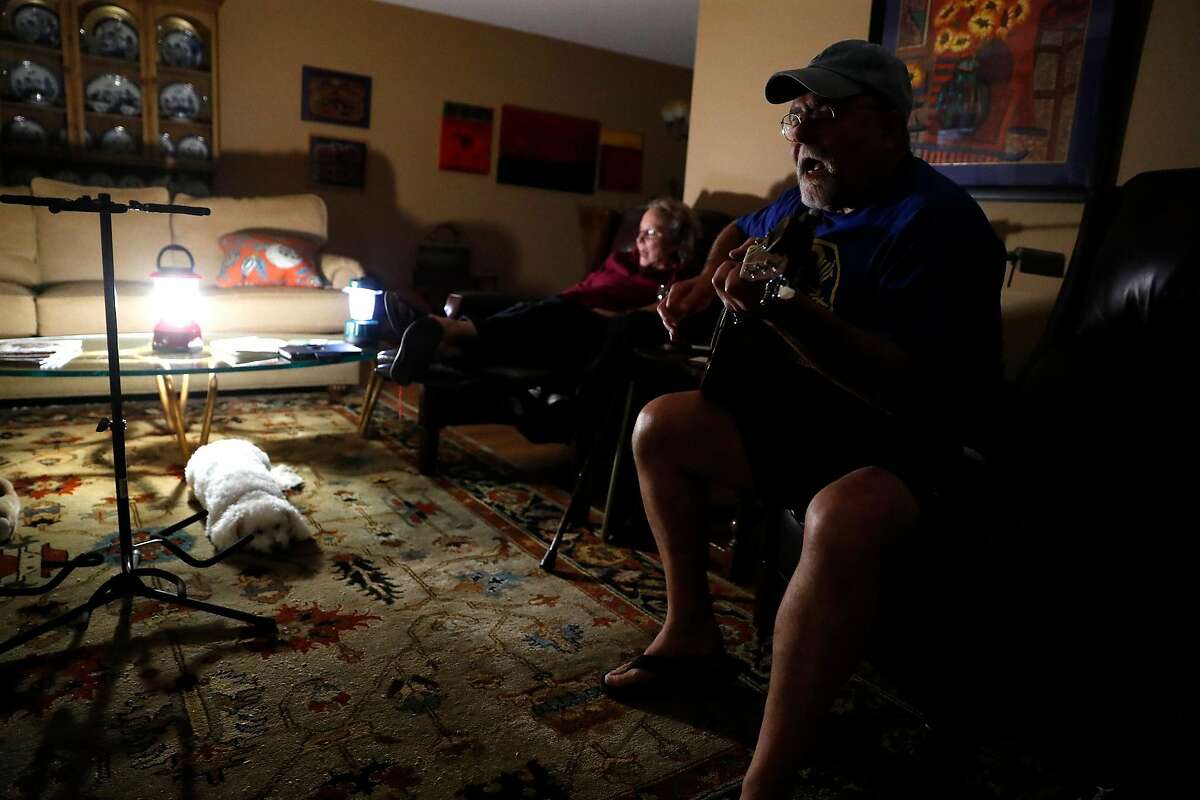 Cathy Nelson sings along as Ken Garcia plays a song during PG&E power shut-off at their home in Santa Rosa, Calif., on Wednesday, October 23, 2019.
