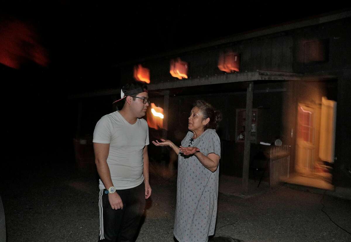 Maria Pelayo says she doesn't want to evacuate until the morning as her son, Manuel Arzate tries to convince her to lieave as the Kincade Fire burns outside Geyserville, Calif., on Thursday, October 24, 2019.