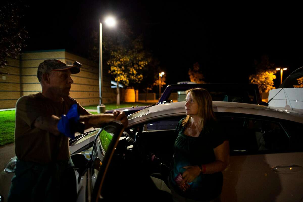 Matt and Mary Ceglarski-Sherwi (who rent a home in Geyserville) in front of their car, at the evacuation center at Windsor High School, Windsor, California, October 24th, 2019. Mary has bad asthma, the smoke woke her at 2:30am, much as it did during the Tubbs fire where their home bunt down.