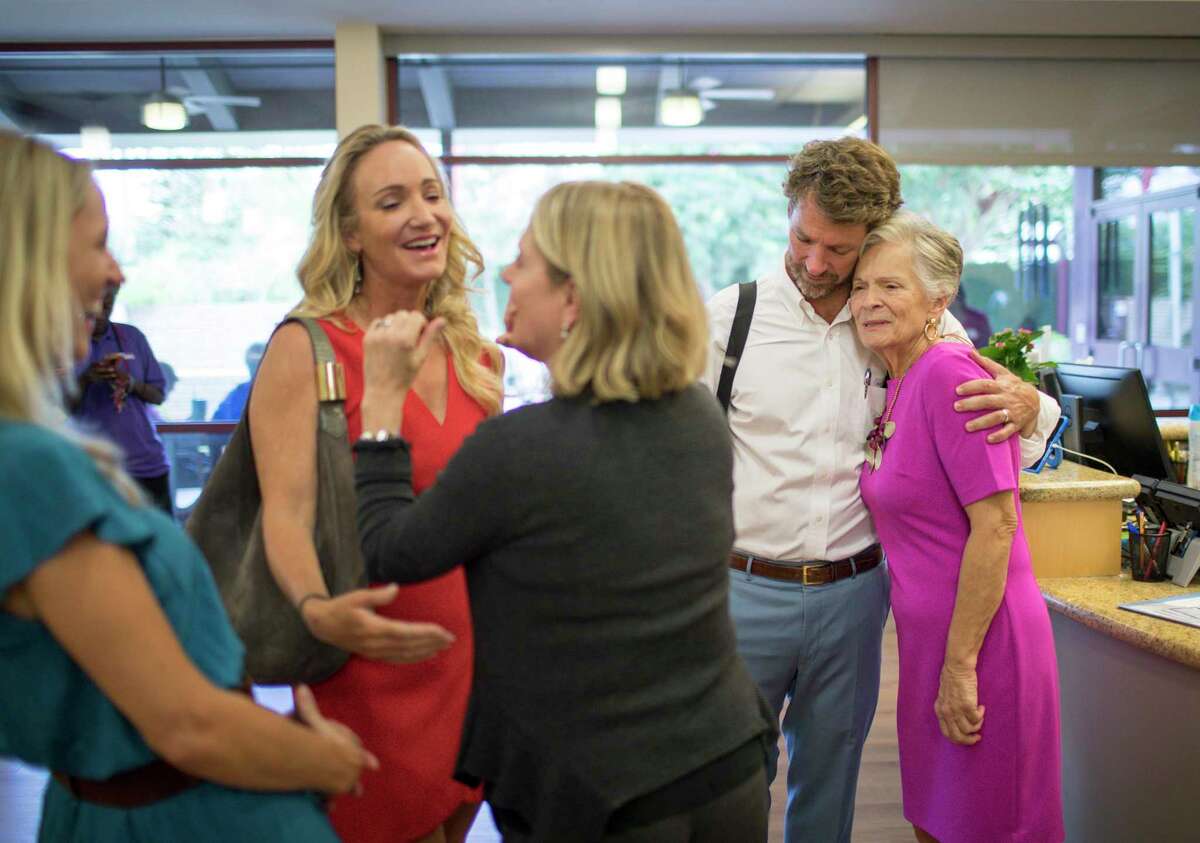 Ryan McCord hugs his mother Jane McCord, who suffers from Alzheimer's disease, as his two sisters talk with Tracey Brown, executive director of Amazing Place, on Thursday, Oct. 10, 2019, in Houston. Amazing Place is a faith-based, non-residential day program for people with mild to moderate dementia.