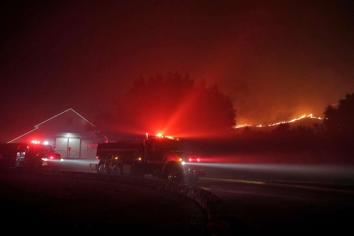 Firefighters stage near the Robert Young Winery as the Kincade Fire burns outside Geyserville, Calif., on Thursday, October 24, 2019.