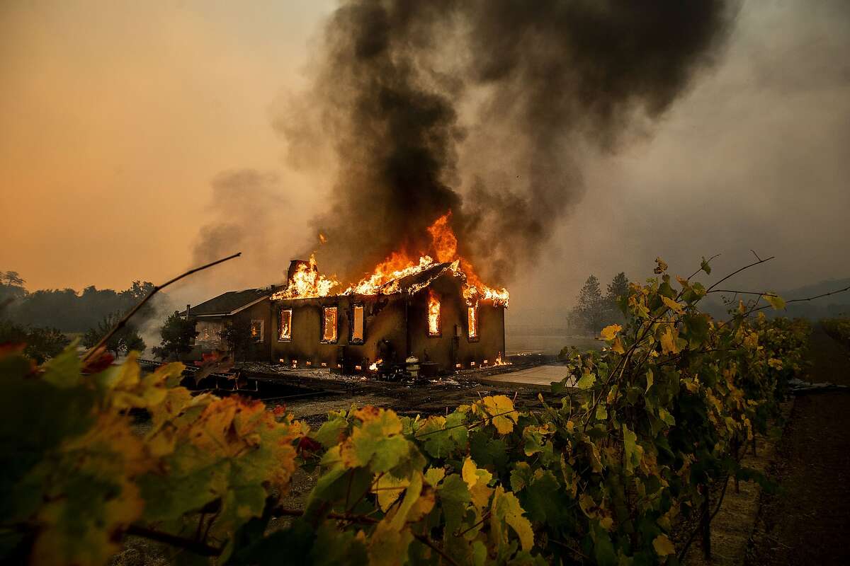 Vines surround a burning building as the Kincade Fire burns through the Jimtown community of unincorporated Sonoma County, Calif., on Thursday, Oct. 24, 2019. (AP Photo/Noah Berger)