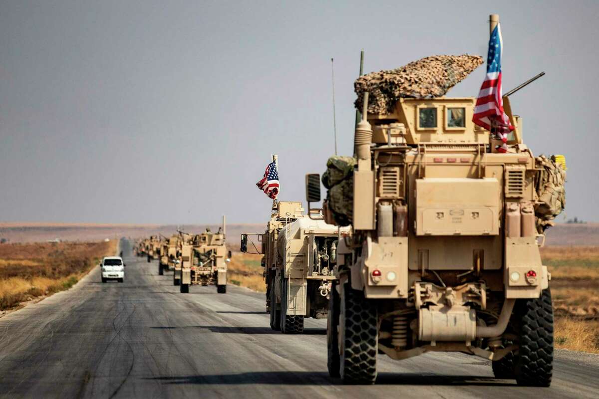 U.S. military vehicles drive on a road in the town of Tal Tamr this month after pulling out of their base. A reader says President Donald Trump betrayed many more than just the Kurds when he withdrew troops from Syria.