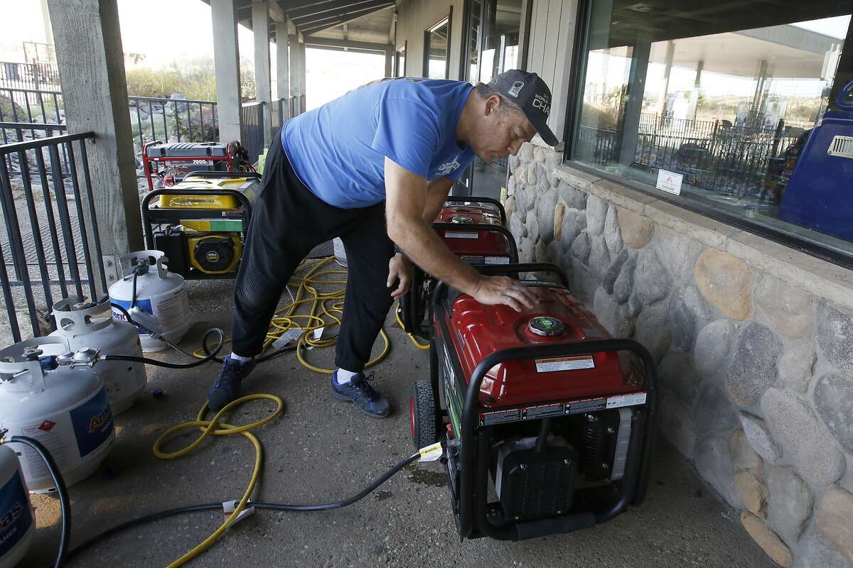Brian Boyd checks one of the generators used to provide power at the Clear Creek Crossing store near Paradise, Calif., Thursday, Oct. 24, 2019. The Pacific Gas & Electric Co. cut power to 17 counties in Northern California to help prevent wildfires caused by downed power lines. Boyd said generators were brought to the store to provide power to the refrigerators and to provide some service to area residents. (AP Photo/Rich Pedroncelli)