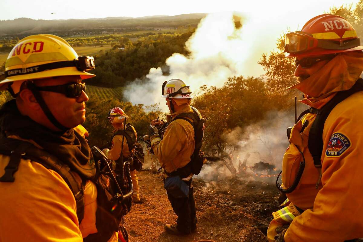 Monterey Strike team firefighters watch over the Kincade Fire in Geyserville, California, on Thursday, Oct. 24, 2019.