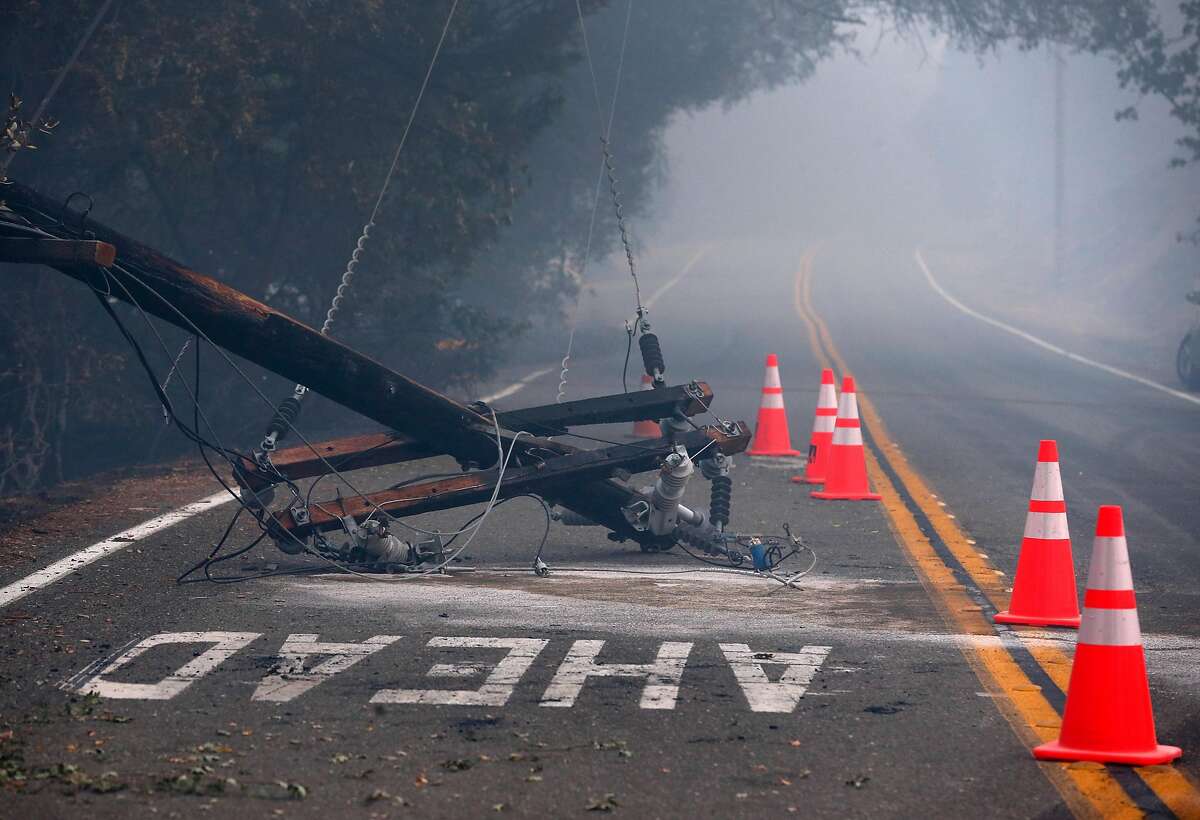 Safety cones surround a toppled utility pole on Geysers Road as the Kincade Fire continues to burn near Geyserville, Calif. on Friday, Oct. 25, 2019.