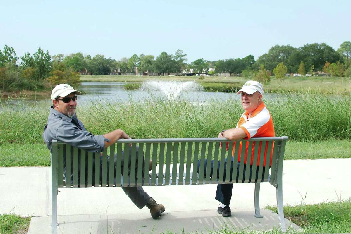 Exploration Green land steward and master naturalist George Kyame sits with Frank Weary next to the pond at at Exploration Green park phase I.