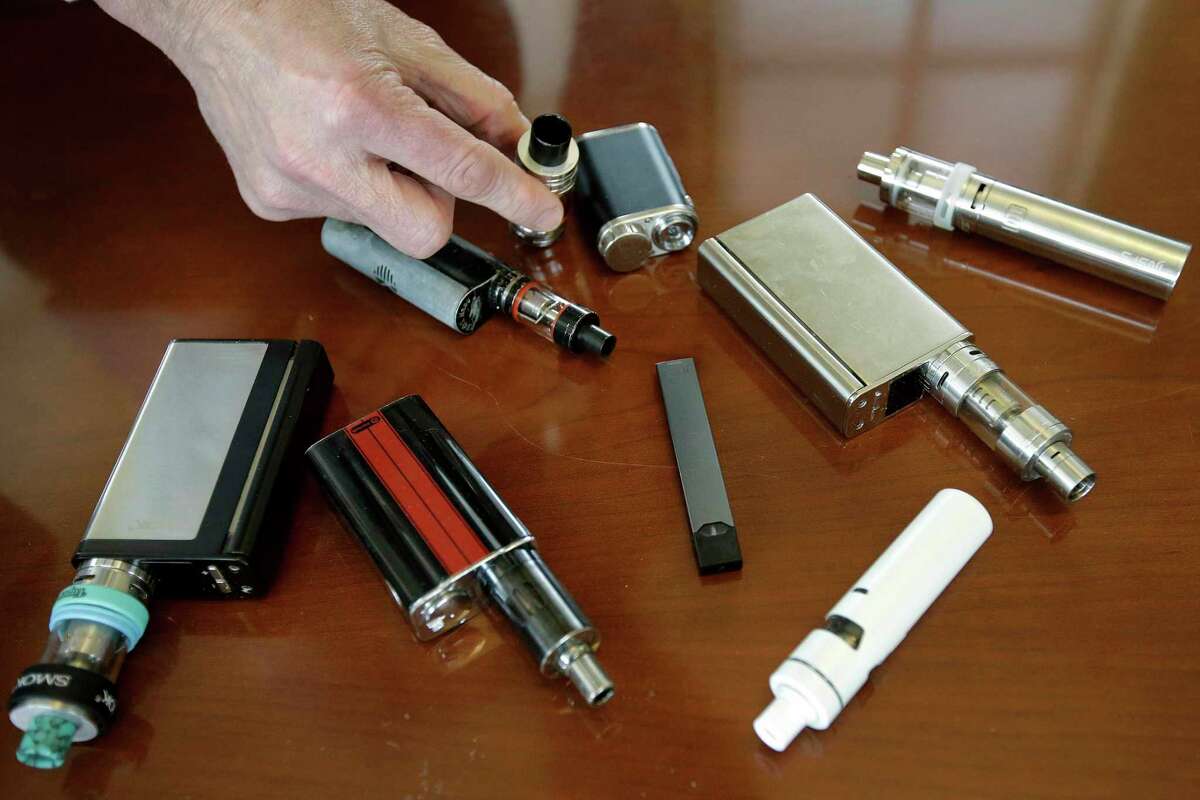 A high school principal displays vaping devices that were confiscated from students at a school in Massachusetts.