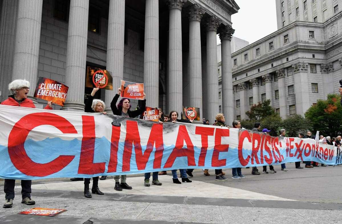 Climate activists protest on the first day of the ExxonMobil trial outside the New York State Supreme Court building on October 22, 2019 in New York City. - Charges that Exxon Mobil misled investors on the financial risks of climate change will be heard in court after a New York judge gave the green light for a trial. (Photo by Angela Weiss / AFP) (Photo by ANGELA WEISS/AFP via Getty Images)