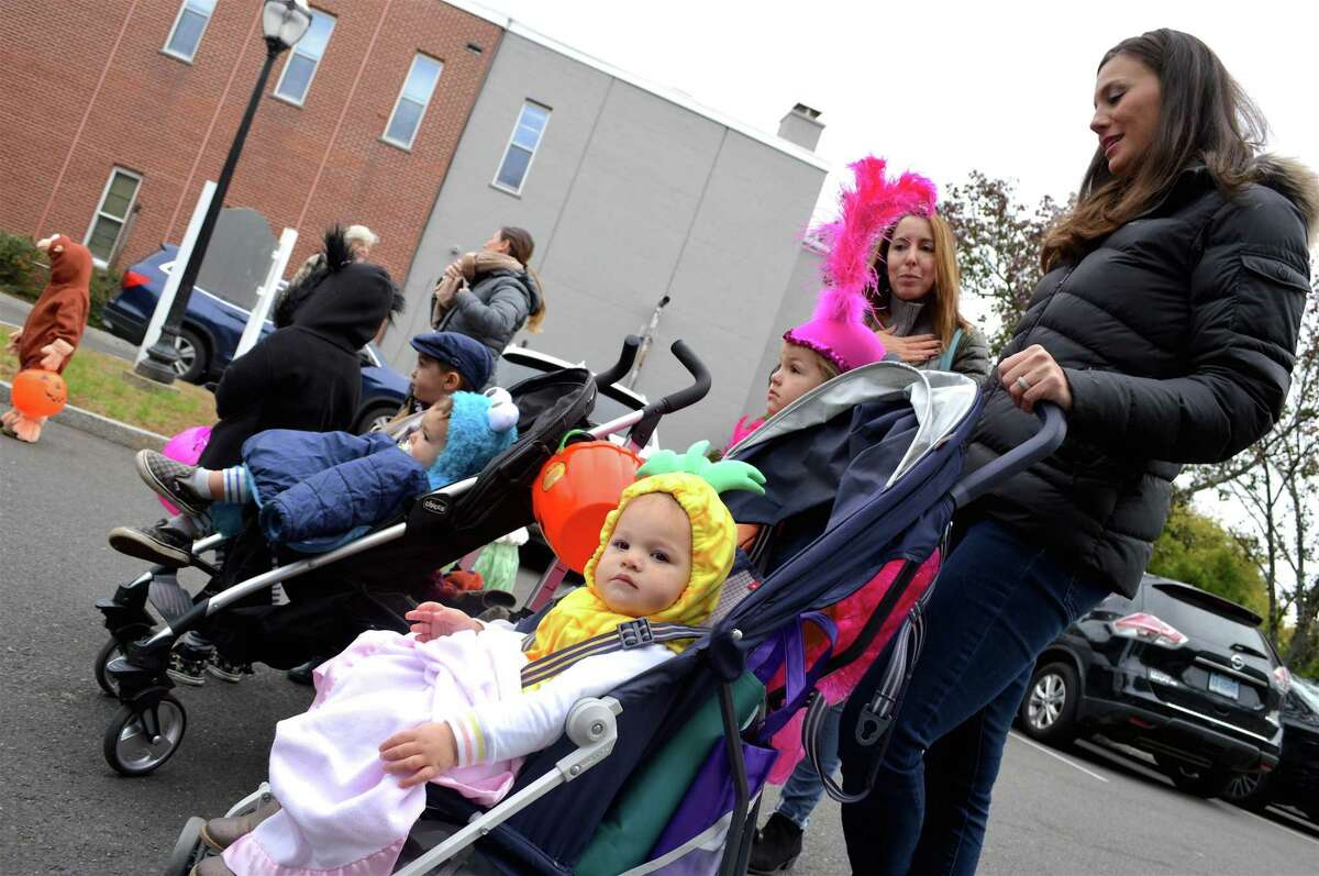 Arden Kearney, 1, of Darien, waits near the firehouse for the trick or treating to start at the Darien Community Association's annual Halloween parade, Friday, Oct. 26, 2018, in Darien, Conn.