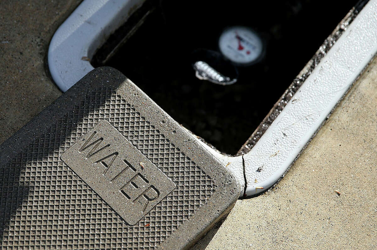 FILE - A cover sits next to a water meter on April 7, 2015 in Walnut Creek, California. EBMUD is preparing its customers for issues during the electricity shut-offs from PG&E, and is asking that people minimize water use.