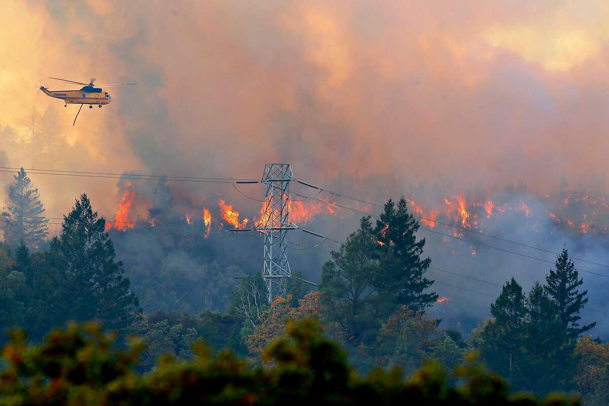 Helicopters dump water down to the Kincade Fire off of Pine Flat Road on Friday, Oct. 25, 2019, east outside of Geyserville, Calif.