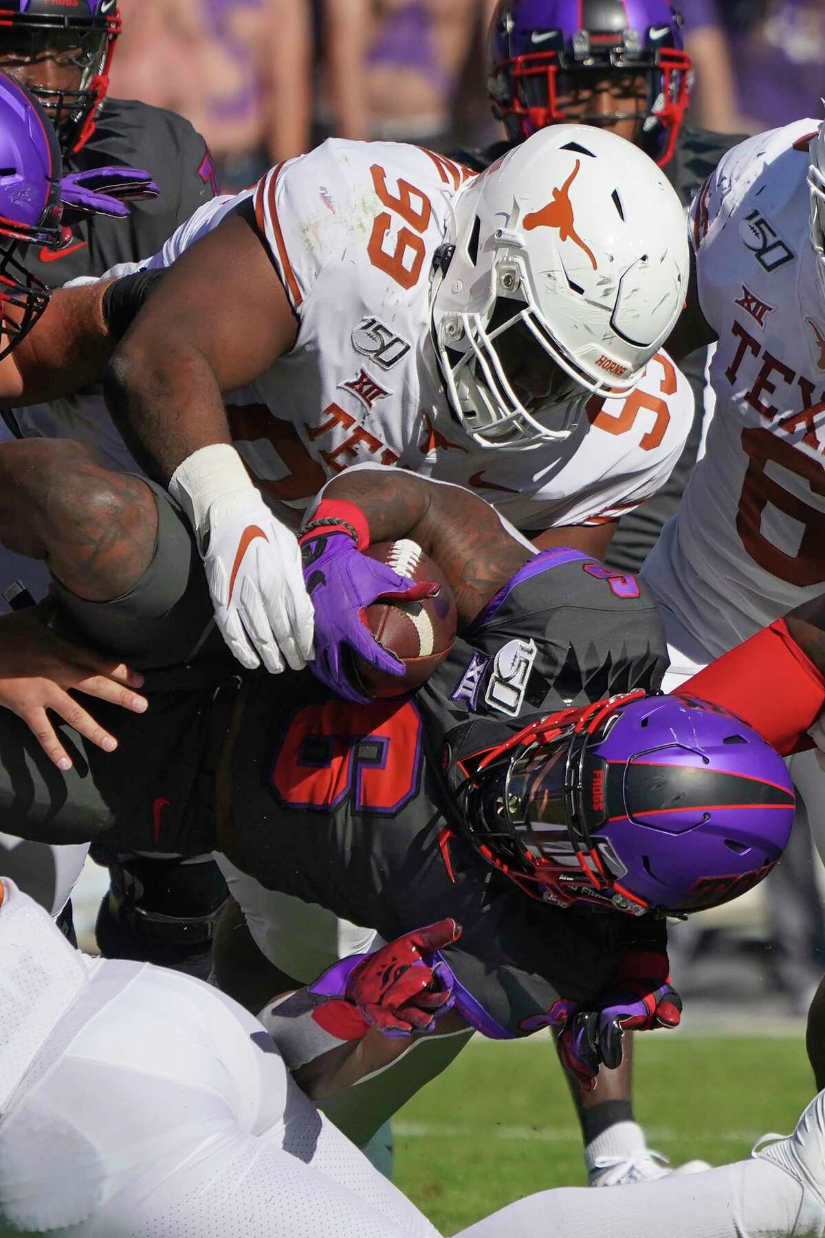 Texas defensive lineman Keondre Coburn (99) tackles TCU running back Darius Anderson (6) in the first half of an NCAA college football game in Fort Worth, Texas, Saturday, Oct. 26, 2019. (AP Photo/Louis DeLuca)