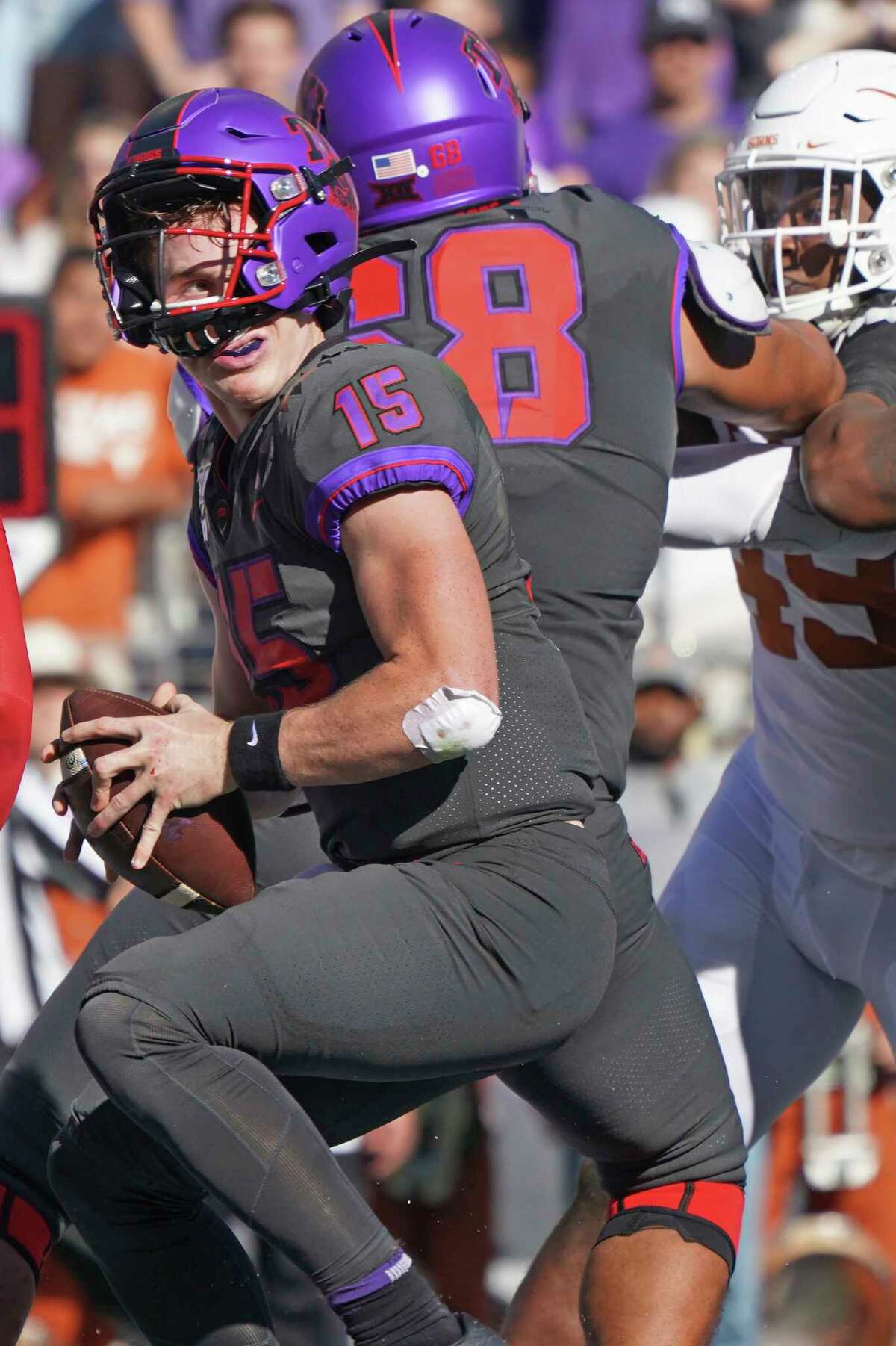 TCU quarterback Max Duggan (15) scrambles out of the pocket in the first half of an NCAA college football game against Texas in Fort Worth, Texas, Saturday, Oct. 26, 2019. (AP Photo/Louis DeLuca)