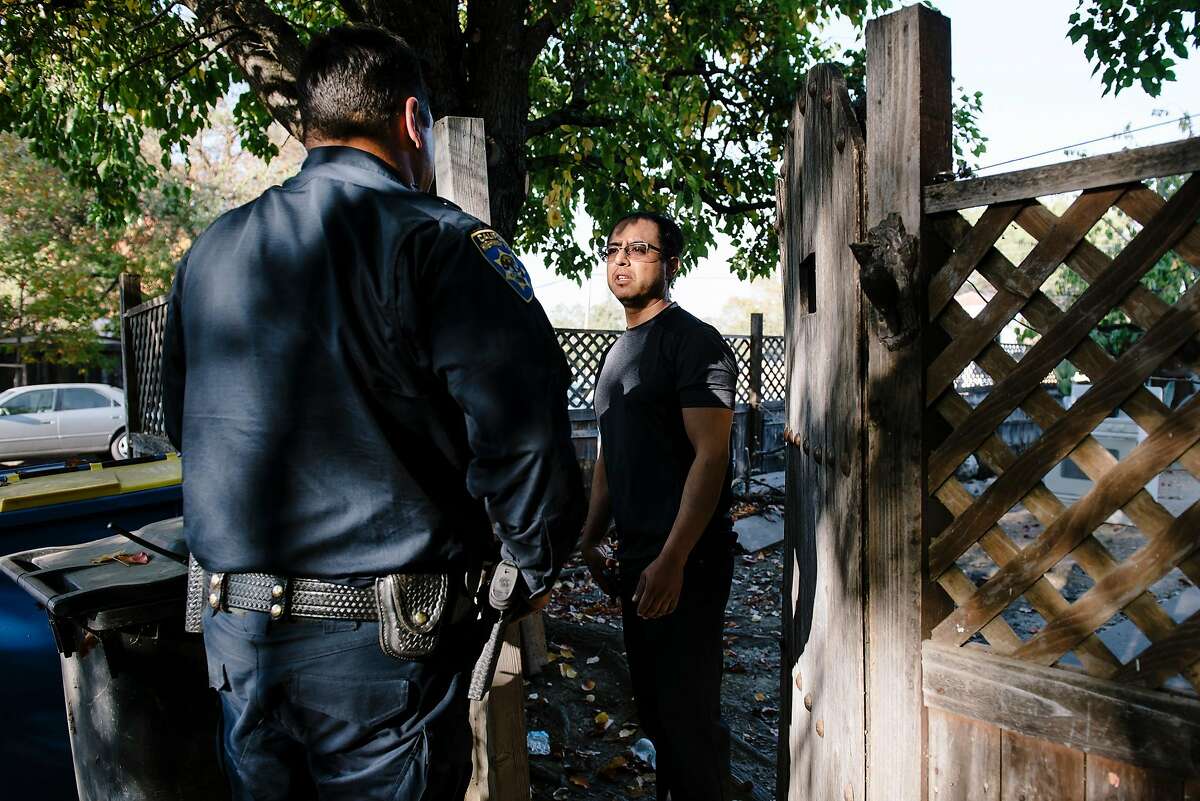 While checking if residents have heeded the mandatory evacuation notices, Officer Tony Wold with the California Highway Patrol's Valley Division, left, speaks with resident Ubdlao Molina who said he is waiting for his father to show up before evacuating, in Windsor, California, on Saturday, Oct. 26, 2019.