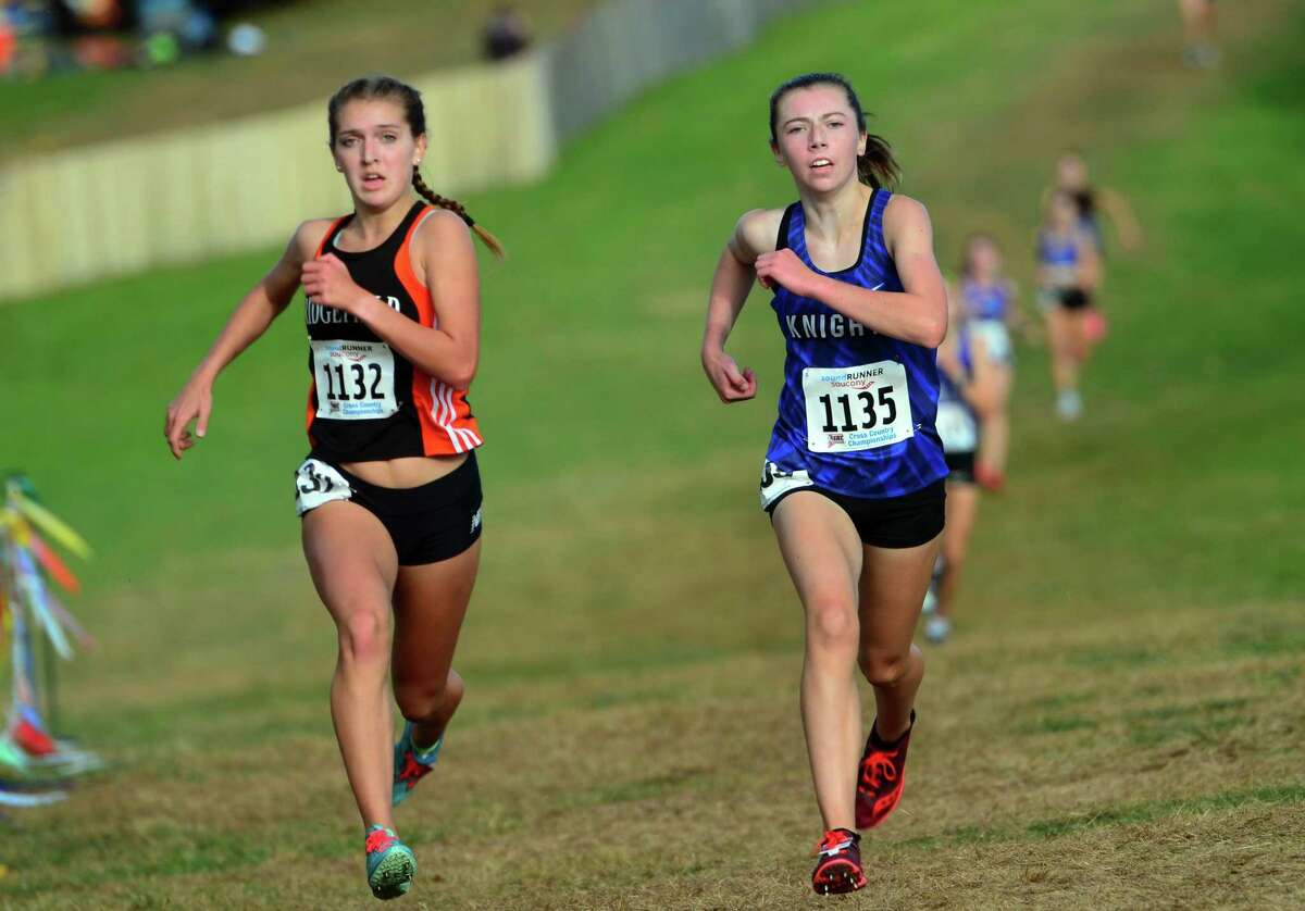 Ridgefield's Tess Pisanelli, left, and Southington's Jacqueline Izzo run neck and neck to the finish line during Class LL cross country championship action in Manchester, Conn., on Saturday Oct. 26, 2019.
