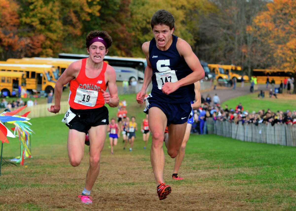 Staples' Morgan Fierro, center, stays ahead of Conrad's Callum Sherry to cross the finish line for third place during Class LL cross country championship action in Manchester, Conn., on Saturday Oct. 26, 2019.