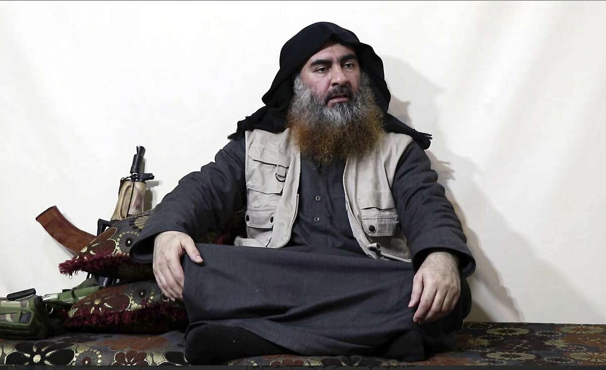 FILE - This file image made from video posted on a militant website April 29, 2019, purports to show the leader of the Islamic State group, Abu Bakr al-Baghdadi, being interviewed by his group's Al-Furqan media outlet. The IS erupted from the chaos of Syria and Iraq's conflicts and swiftly did what no Islamic militant group had done before, conquering a giant stretch of territory and declaring itself a "caliphate." U.S. officials said late Saturday, Oct. 26, 2019 that al-Baghdadi was the target of an American raid in Syria and may have died in an explosion. (Al-Furqan media via AP, File)