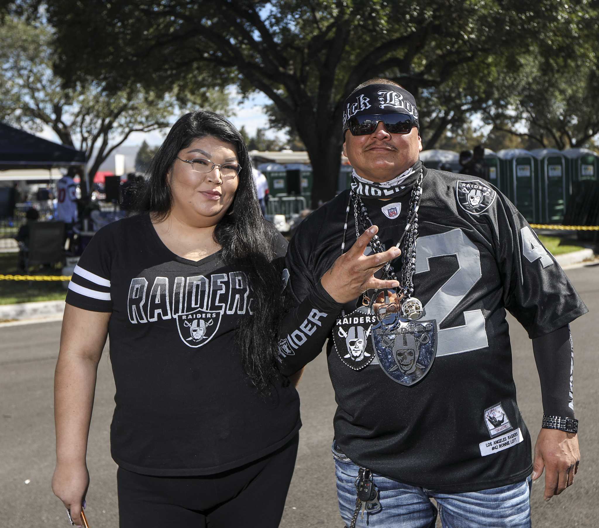 Oakland Raider fans pose during tailgating festivities before game