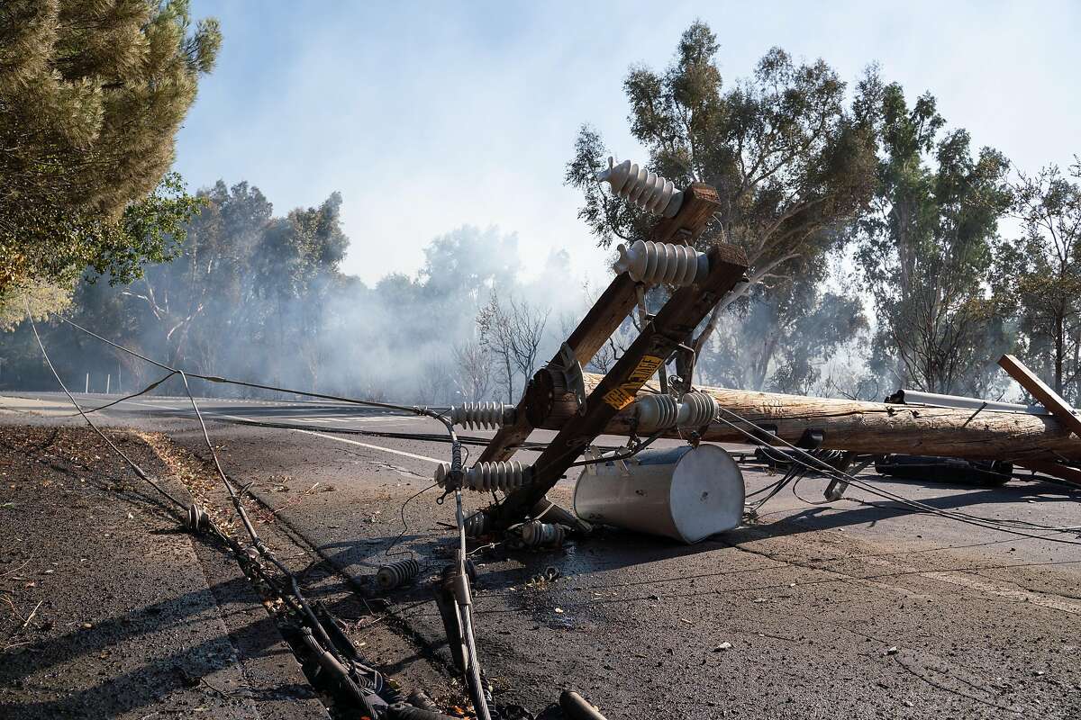 A power line collapses after a fire near the Lafayette Tennis Club, in Calif. on Sunday, Oct. 27, 2019.