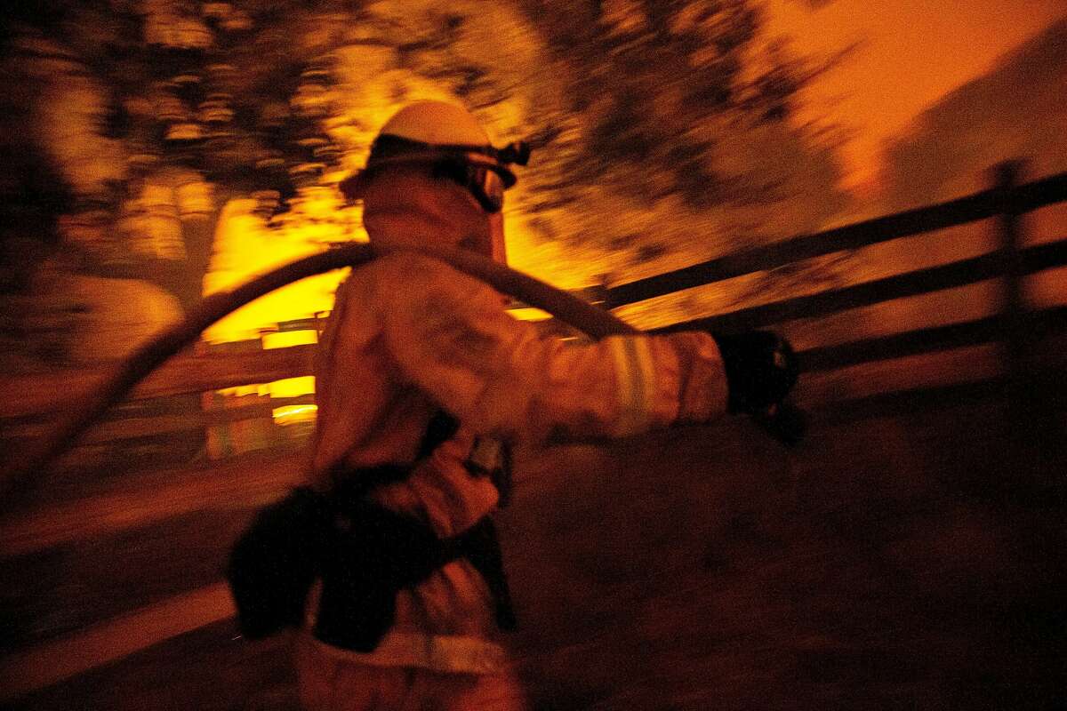 Richard Lais of the Palo Alto Fire Department battles the Kincade Fire along Chalk Hill Road on Sunday, Oct. 27, 2019, in Healdsburg, Calif.