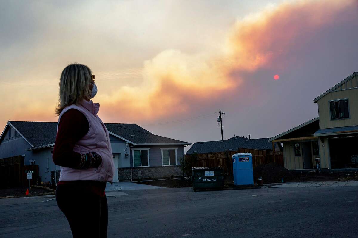 Liz Neves along Keoke Court in the Coffey Park neighborhood as smoke from the Kincade Fire fills the air on Sunday, Oct. 27, 2019, in Santa Rosa, Calif. Neves lives in her rebuilt home along Keoke Court at Mocha Lane in the Coffey Park neighborhood, where there’s an evacuation warning in place. Neves, her husband and her neighbor take shifts sleeping to make sure someone is awake if an evacuation is ordered. She’s been living in the neighborhood for more than 30 years. The Coffey Park neighborhood continues to rebuild after it was destroyed in the Tubbs Fire of October 2017.