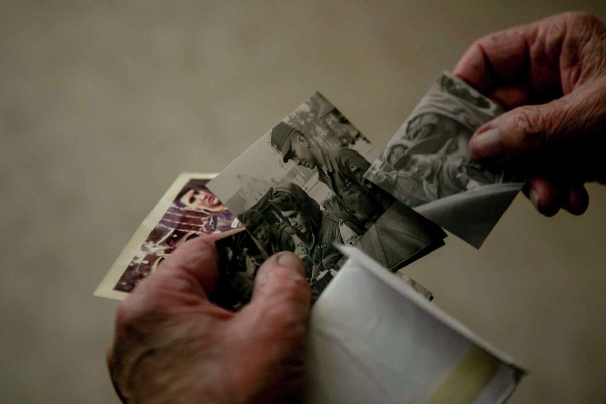 In his San Antonio home, Larry Lupear shows photos he treasures from his time in the Army stationed in Germany with Elvis Presley.