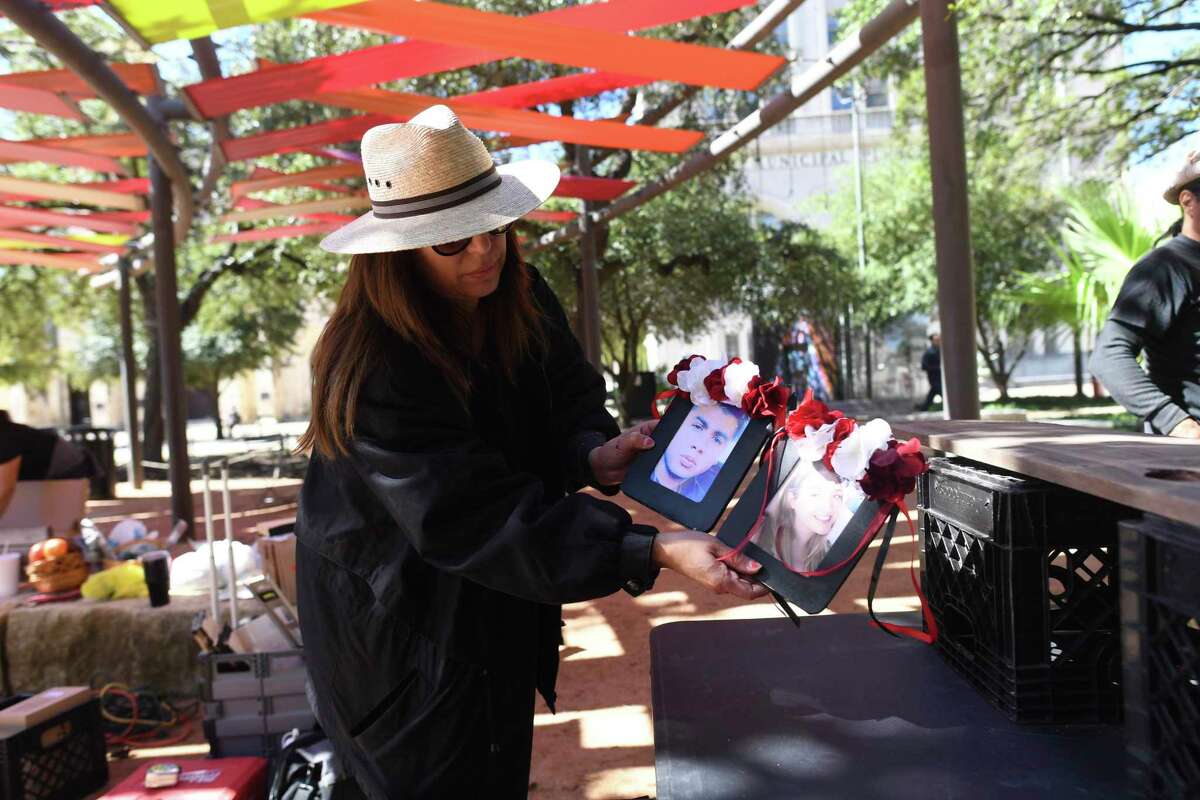 Artist Laura Varela prepares pictures of the deceased in the WalMart mass shooting in El Paso as she sets up a Dia de los Muertos altar in Main Plaza on Friday, Oct. 25, 2019. Three altars for Dia de los Muertos are on display at the site. One, by Kathy Sosa, is dedicated to victims of domestic violence, and another is being built by Elizabeth Rodriguez to remember Texas musicians who have recently died.