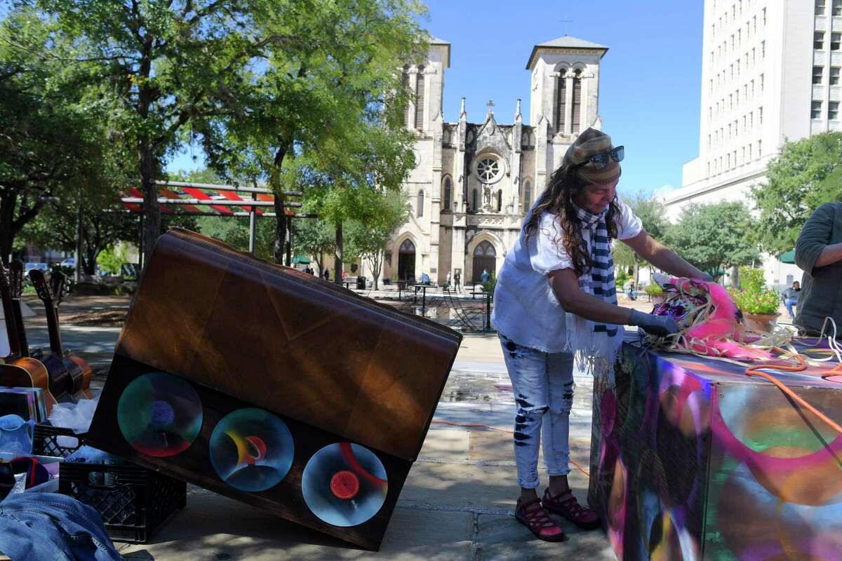 Artist Elizabeth Rodriguez sets up an altar to remember Texas musicians who have recently died in Main Plaza on Friday, Oct. 25, 2019. Three altars for Dia de los Muertos are on display at the site. One, by artist Laura Varela, honors the deceased in the WalMart mass shooting on Aug. 3, 2019. Another, by Kathy Sosa, is dedicated to victims of domestic violence.
