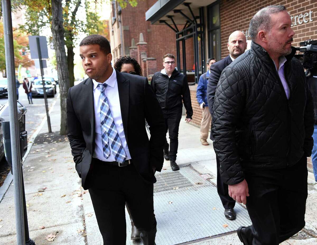 Hamden police Officer Devin Eaton, left, walks down Church Street following his arraignment in Superior Court in New Haven on charges of first-degree assault and two counts of first-degree reckless endangerment on Oct. 28, 2019.