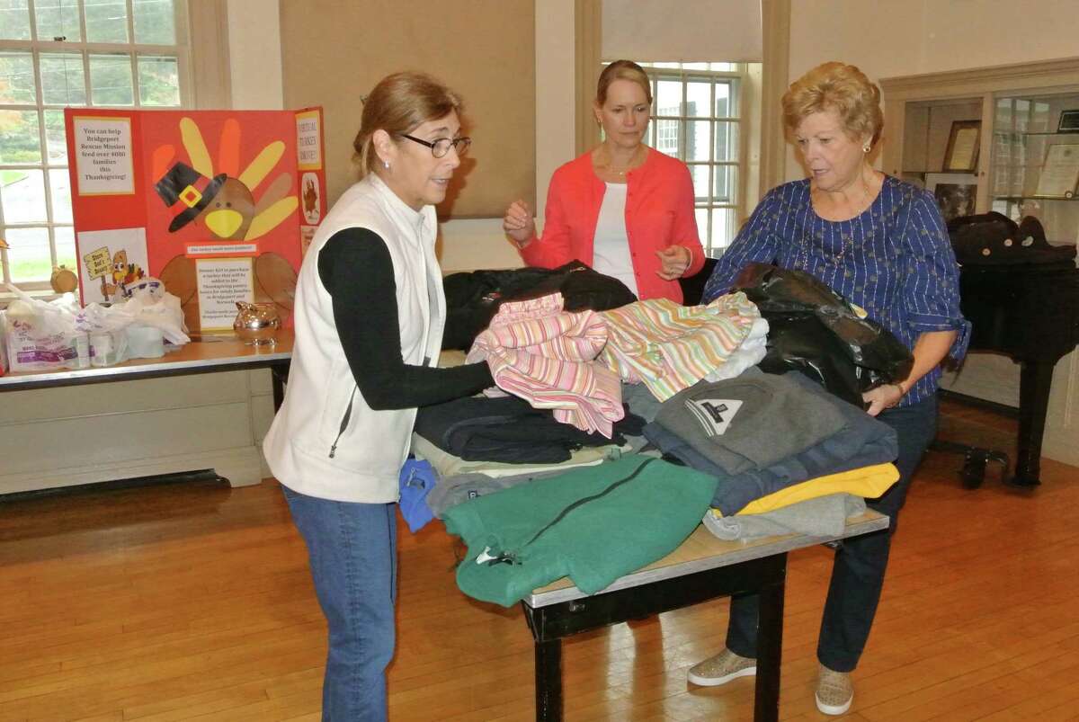 From left, Marie Broderick, Kathy Scheller, and Carol Boehly sort donated coats and linens during a previous coat drive at the Wilton Congregational Church.