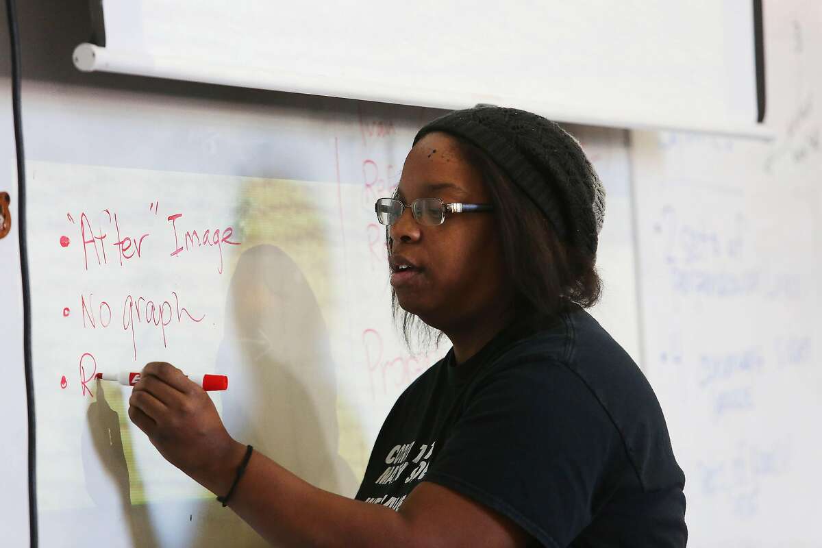 Mission High School math teacher Kimberly Rosario writes on a white board while teaching Geometry class at Mission High School on Monday, October 28, 2019 in San Francisco, Calif.